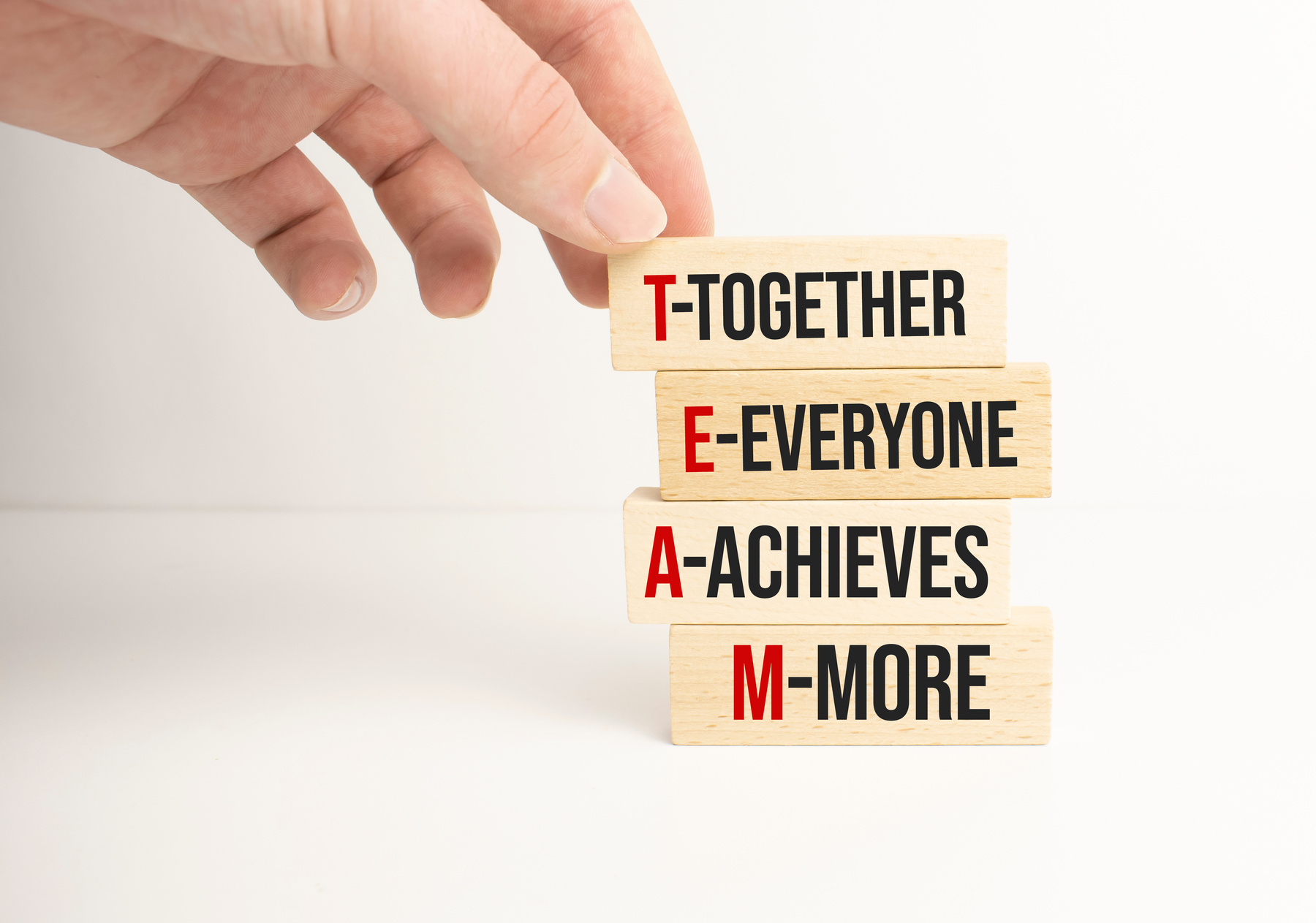 TEAM, together everyone achieves more symbol. Wooden cubes with words